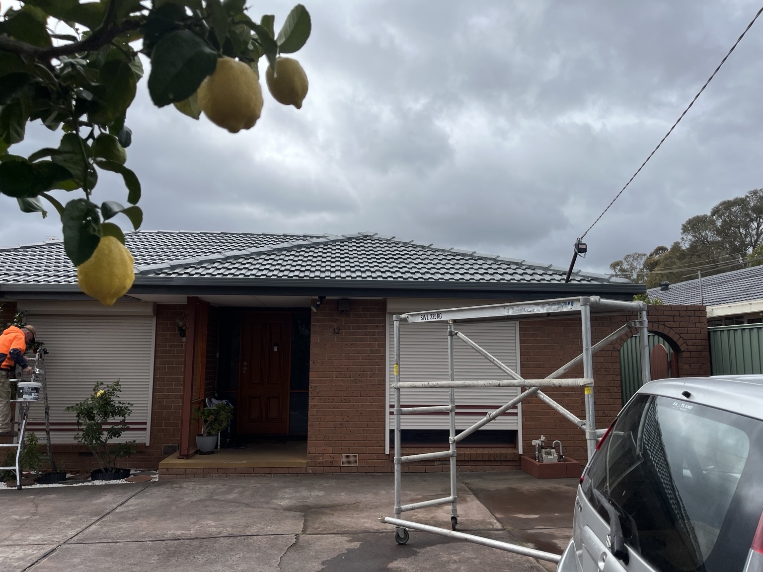 Completed residential tiled roof with work crew