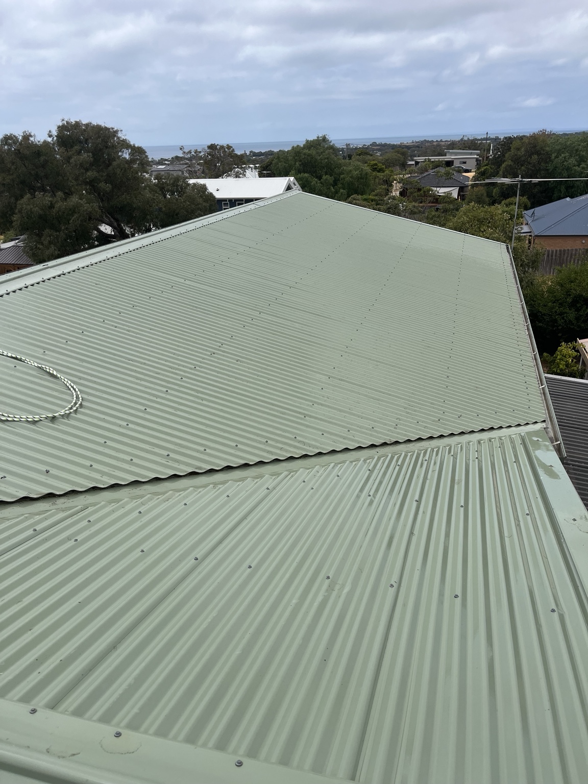 Cleaned pale green metal roof near the coast